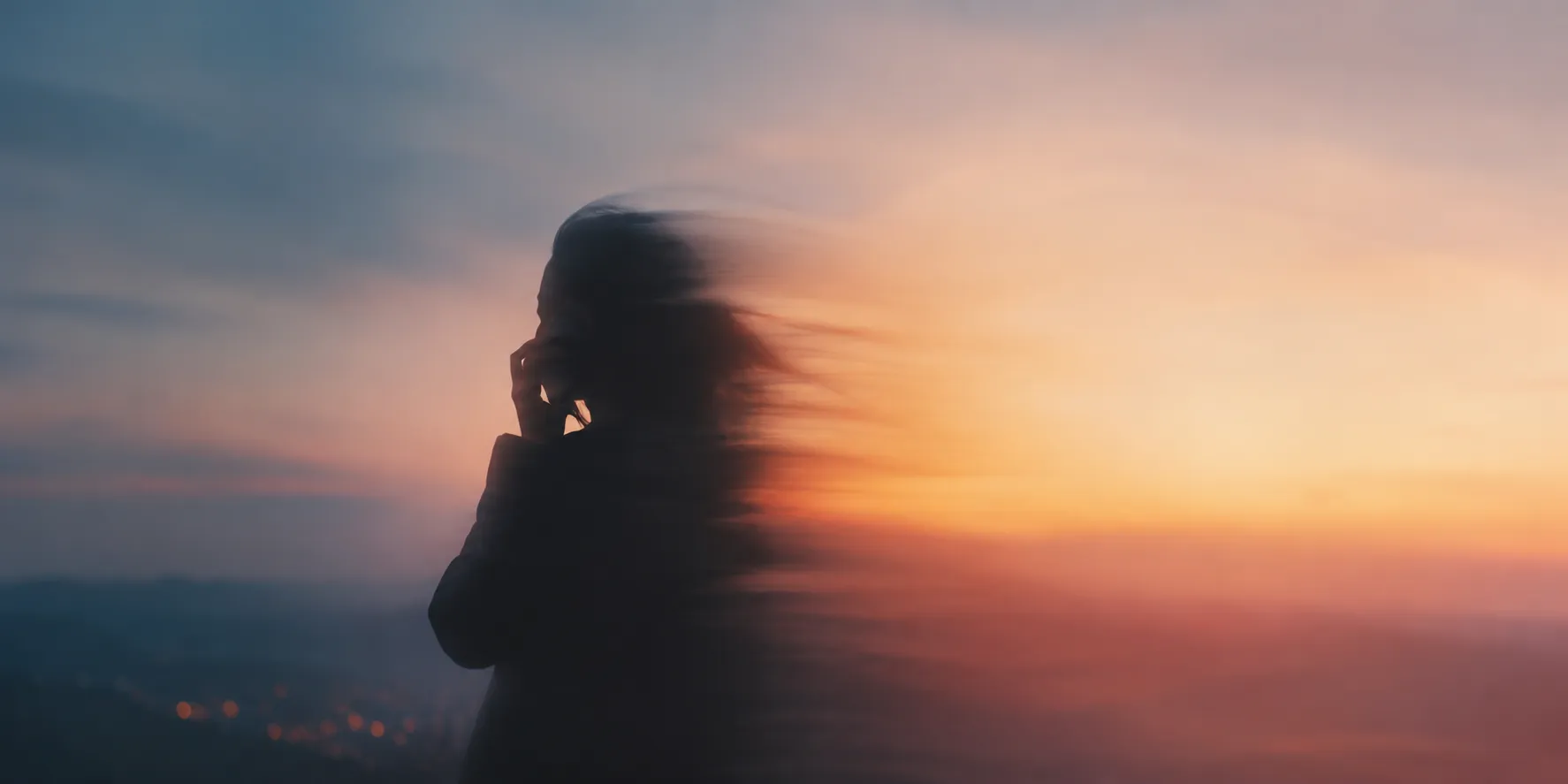 Silhouette of a person on a phone call at dusk
